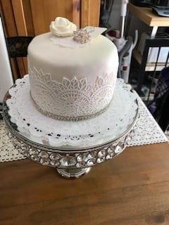 Here is a light pink and white cake that should be shown at a wedding. It has an intricate lace design wrapped around the base. Have Dover NH wedding with us!