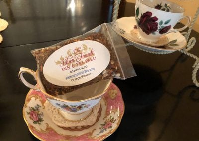 Our hotel near seacoast nh comes with all sorts of surprises. This image shows a table at our tea parlor. There is a beautiful tea cup with a personalized bag of our loose leaf tea sitting on top. The tea is orange blossom.