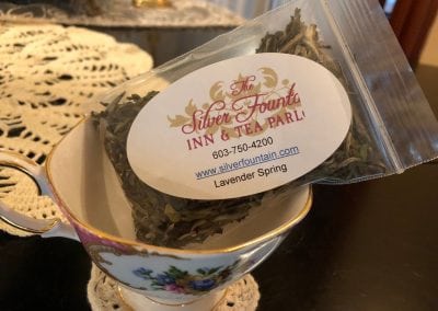 This is a small bag of Lavender Spring tea sitting in a tea cup. Part of the experience of one of the best hotels in durham nh. The tea cup has flowers on it.